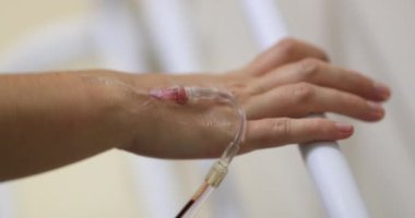 Hands connected to IV drip at hospital