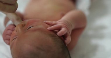 Calming newborn baby by suckling finger feeding