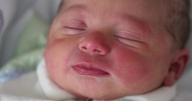 Newborn waking up opening eyes in first day of life
