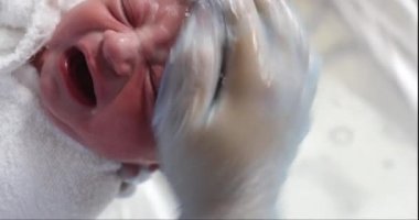 Newborn infant baby taking bath after birth