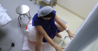 Woman at hospital stretching body with pilates ball before labor