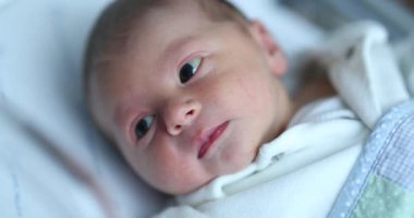 Baby newborn infant inside hospital crib after birth