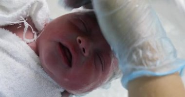 Newborn baby infant taking bath after birth