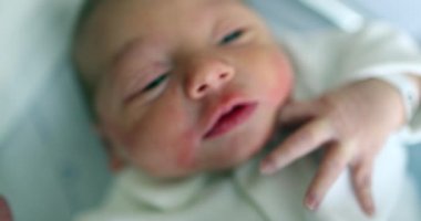 Cute newborn baby first day of life crying, observing world