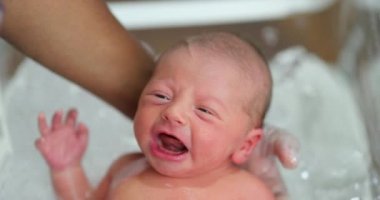 Newborn baby infant taking bath for the first time