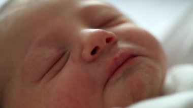 Newborn baby infant sleeping during first day of life after birth