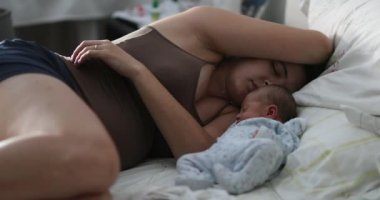 Mom and newborn asleep in bed. Infant baby sleeping with mother in first week of life