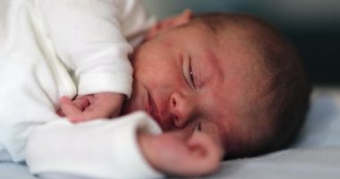 Baby newborn waking up from nap stretching body