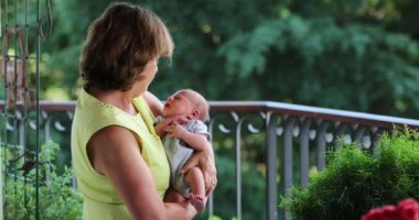 Grand-parent holding newborn baby infant outside showing love care and affection