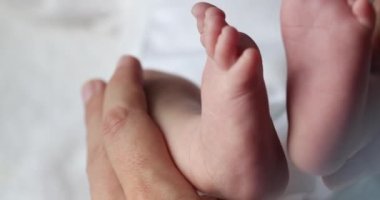 Closeup of newborn baby infant feet and foot in first days of life