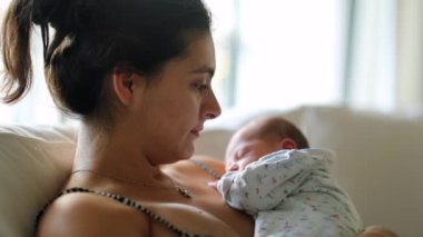Mother kissing newborn baby infant showing love and affection