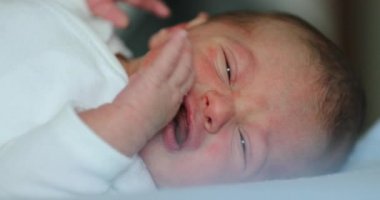 Newborn baby infant crying during first week of life, close-up of baby face