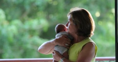 Portrait of grand mother holding newborn baby grand-son
