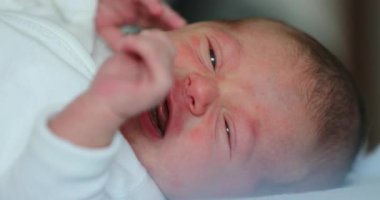 Small Newborn baby infant lying in bed, close-up of baby face
