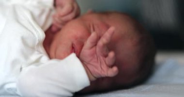 Newborn baby sleeping, infant stretching face and waking up