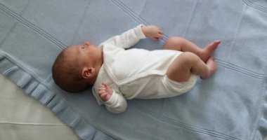 Newborn baby in bed seen from vertical perspective