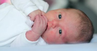 Cute Newborn baby lying in bed during first week of life