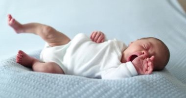 Newborn baby falling asleep taking a nap yawning and going to sleep