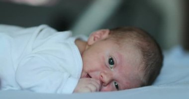 Adorable newborn baby infant smiling feeling happy discovering the world