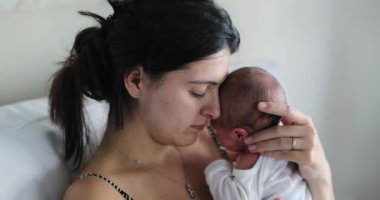 Mom holding newborn baby showing love and affection