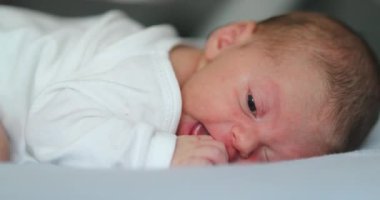 Adorable newborn baby infant smiling feeling happy discovering the world
