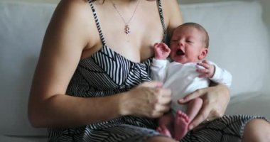 Newborn baby crying being held in mother arms