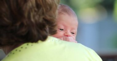 Grandma holding newborn baby grandson