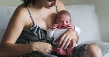 Mom holding newborn baby, first week of life, fragile