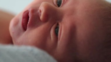 Closeup of newborn baby infant face maco looking and observing