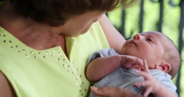 Grand-parent holding baby infant during first month of life interaction