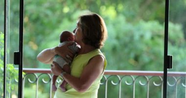 Portrait of grand mother holding newborn baby grand-son