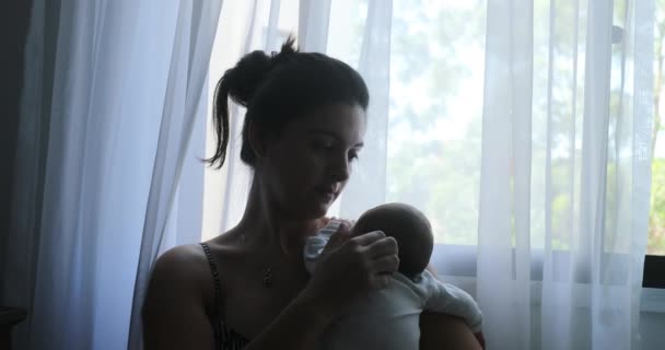 Mother Holding Newborn Baby Next Window — Vídeo de Stock
