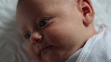 Closeup of baby newborn face laying in bed