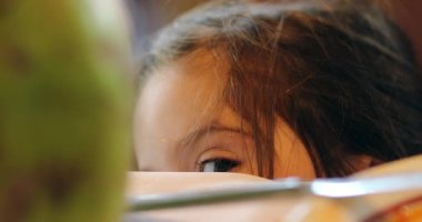 Shy cute little child playing hide and seek peekaboo
