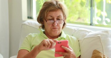 Senior older woman holding smartphone device pressing screen with finger