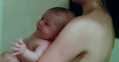 Mother and baby son in shower bathing