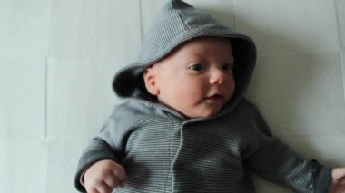 Adorable baby wearing hoodie clothing cute infant toddler in bed