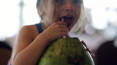 Little girl child drinking coconut water fruit