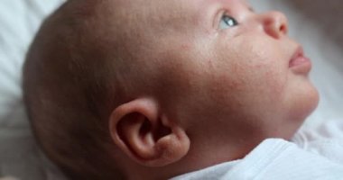 Yeni doğmuş bebek pencereden dışarı bakıyor. Yakın çekim detayları.