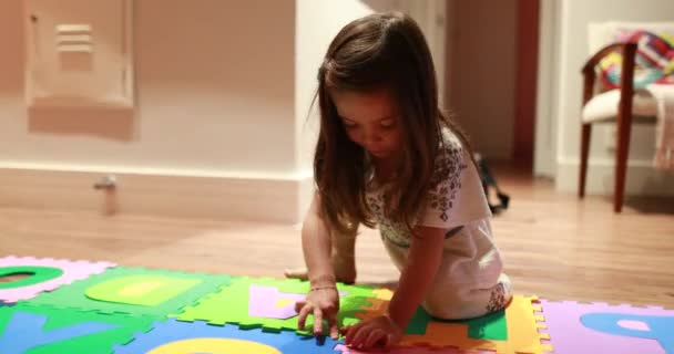 Little Girl Completing Puzzle Pieces Home — Stock Video