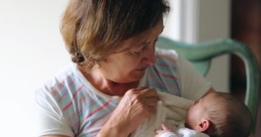 Grand-mother holdingnewborn baby infant candid