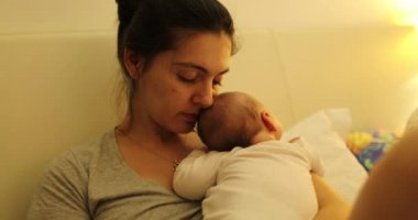 Candid mom holding sleeping newborn baby showing love care and affection