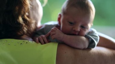 Holding newborn baby infant in arms during first month of life