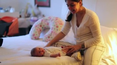 Candid mother in bedroom home with newborn baby infant