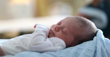 Infant newborn baby face close-up waking up from sleep