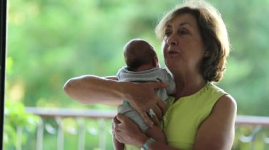 Grandmother holding newborn baby infant in arms