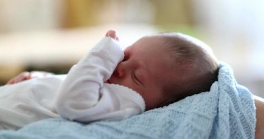 Close-up of newborn baby face waking up from nap