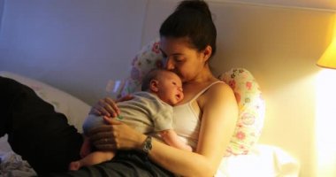 Tired mother with newborn baby at home resting