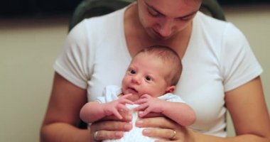 Mother holding newborn baby first month of life portrait