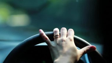 Hand holding steering wheel driving on road